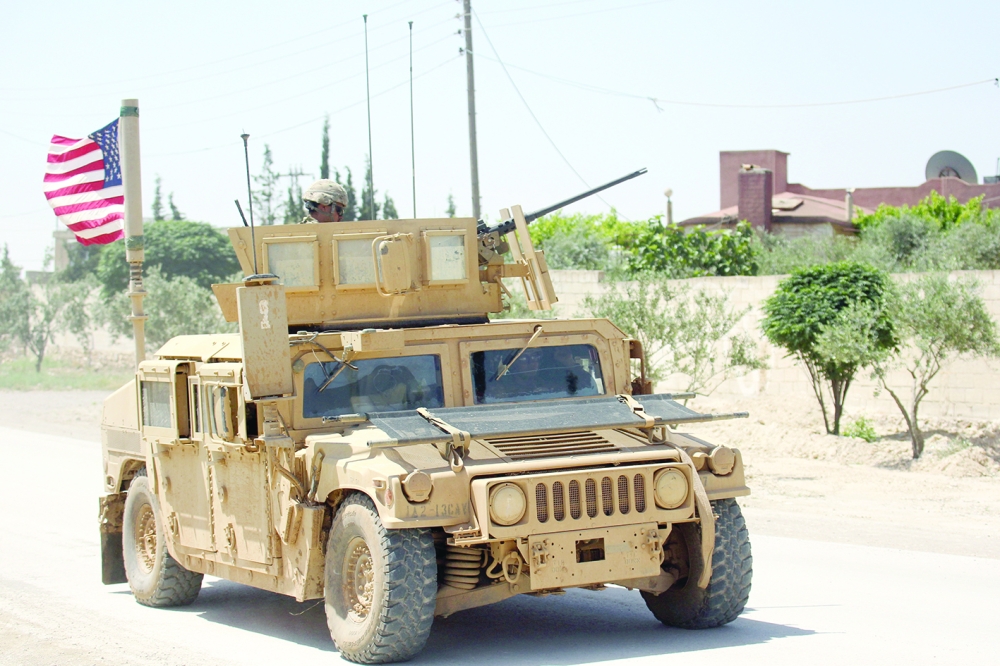 FILE PHOTO:The U.S. flag flutters on a military vehicle in Manbej countryside