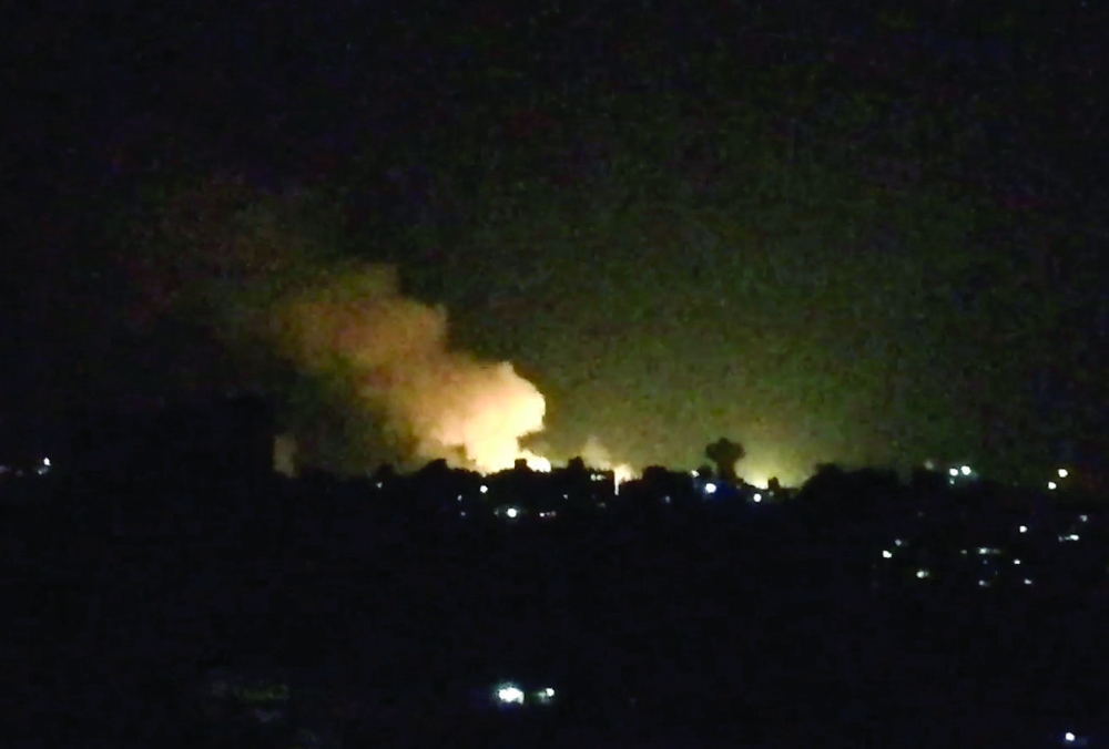 An image grab taken from an AFP video shows what appears to be smoke billowing over buildings near the Syrian capital Damascus, following a reported Israeli air strike overnight on July 1, 2019. - Israeli air strikes near Damascus and in Homs province left more than a dozen people dead,  a Britain-based war monitor said Monday. (Photo by Youssef KARWASHAN / AFP)