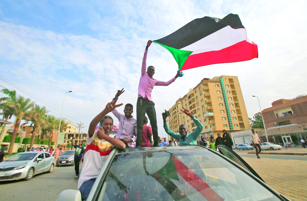 متظاهرون سودانيون يلوحون بأعلامهم الوطنية خلال مظاهرة دعا لها تجمع المهنيين السودانيين            (أ ف ب )