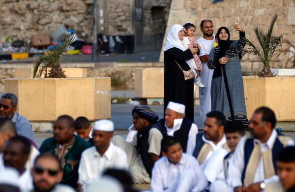 أسرة ليبية تلتقط «سيلفي» قبل صلاة عيد الأضحى في طرابلس أمس   (أ ف ب)